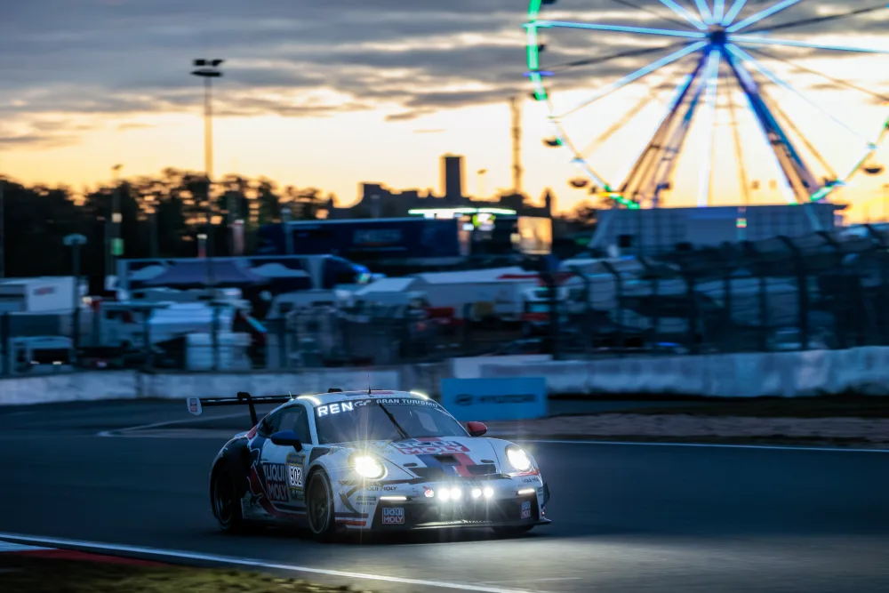 Porsche 911 GT3 Cup in der Dämmerung, beleuchtetes Riesenrad im Hintergrund