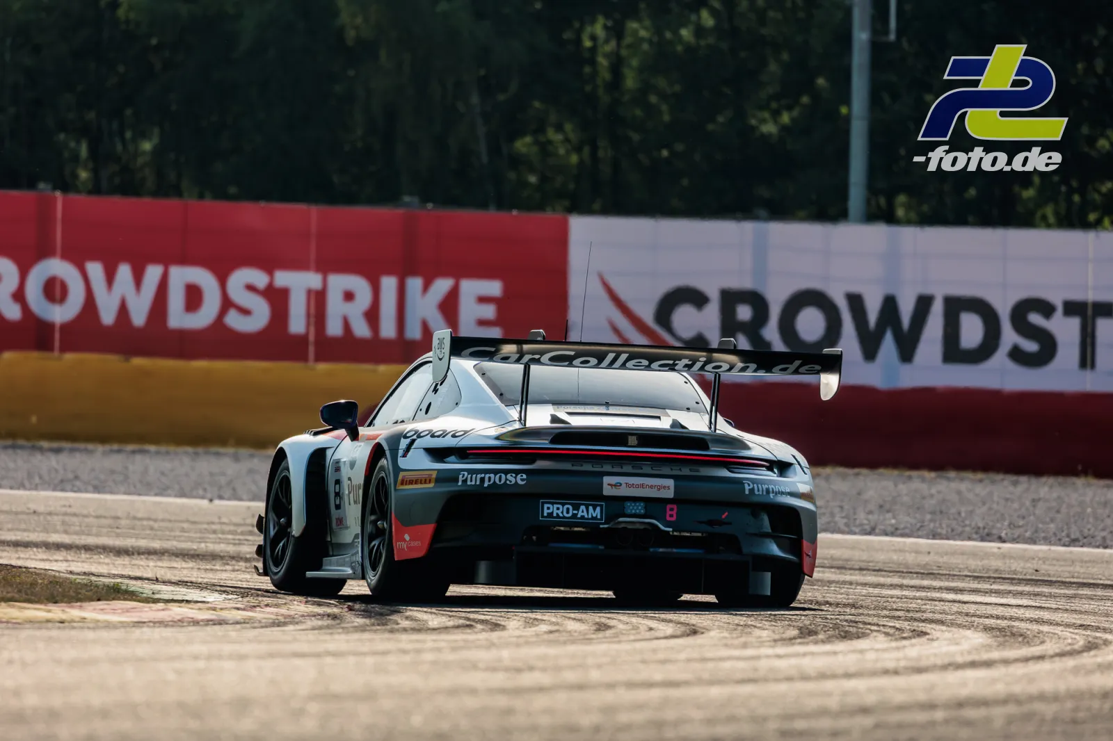 Porsche 911 GT3 R von Car Collection Motorsport in Heckansicht beim 24-Stunden-Rennen von Spa-Francorchamps über Randstein fahrend.