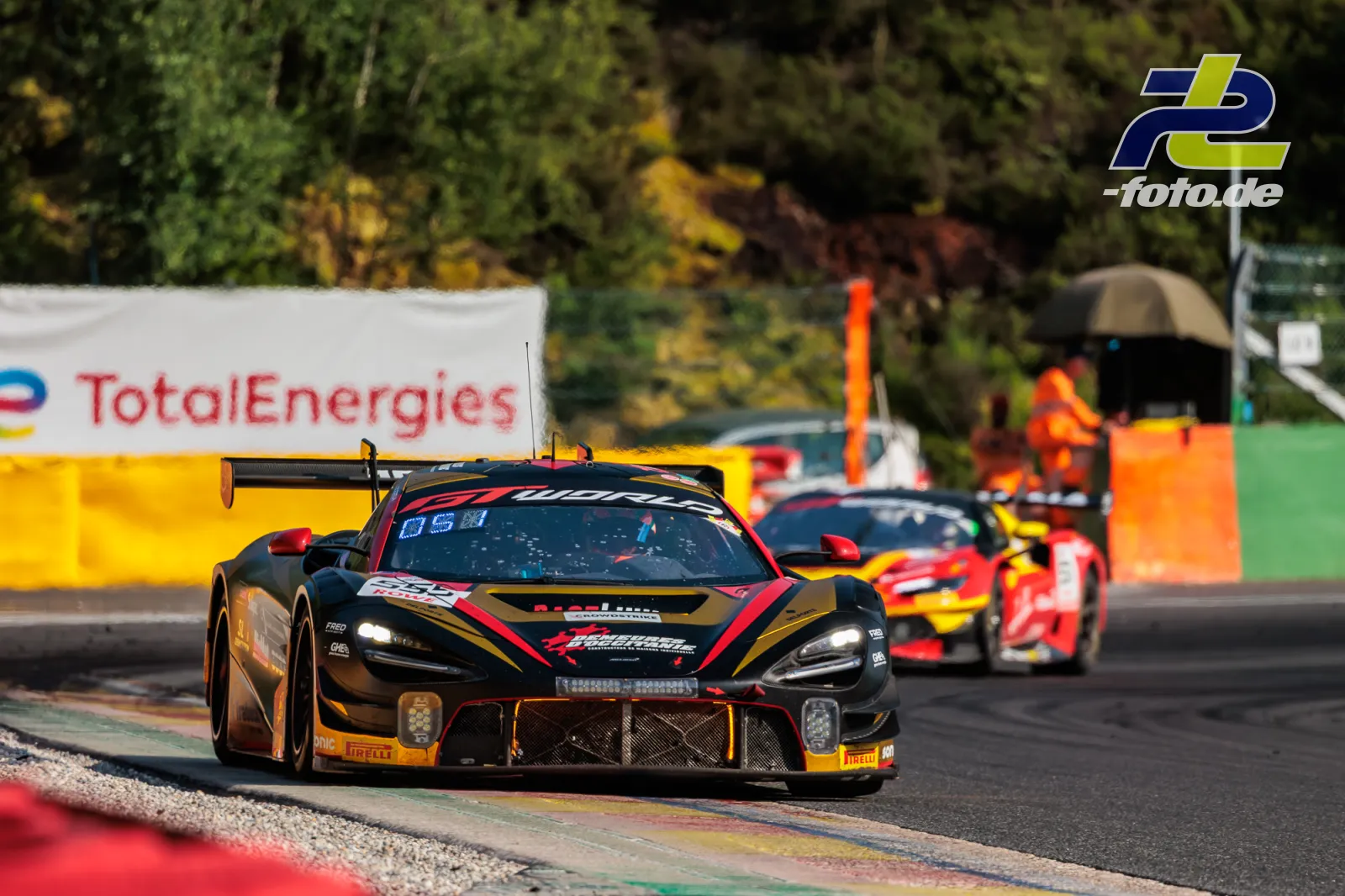 McLaren 720S GT3 EVO #555 von CSA Racing führt eine Gruppe von GT3-Fahrzeugen durch eine Kurve beim 24-Stunden-Rennen von Spa-Francorchamps.