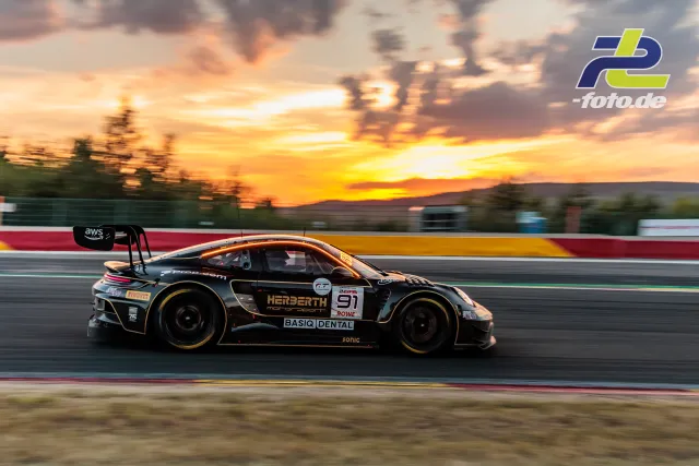 Porsche 911 GT3 R von Herberth Motorsport bei Sonnenuntergang auf der Geraden in Spa-Francorchamps während des 24-Stunden-Rennens.