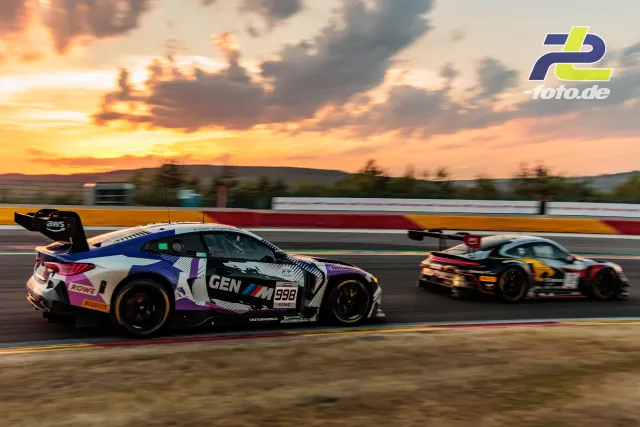 BMW M4 GT3 EVO #998 von Rowe Racing im Mitzieher bei Sonnenuntergang während der 24 Stunden von Spa-Francorchamps, im Hintergrund ein weiterer GT3.