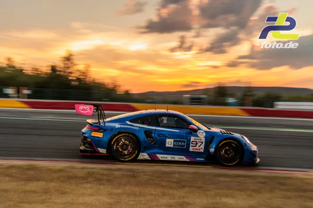 Blauer Porsche 911 GT3 R während der 24 Stunden von Spa bei Sonnenuntergang auf der Rennstrecke
