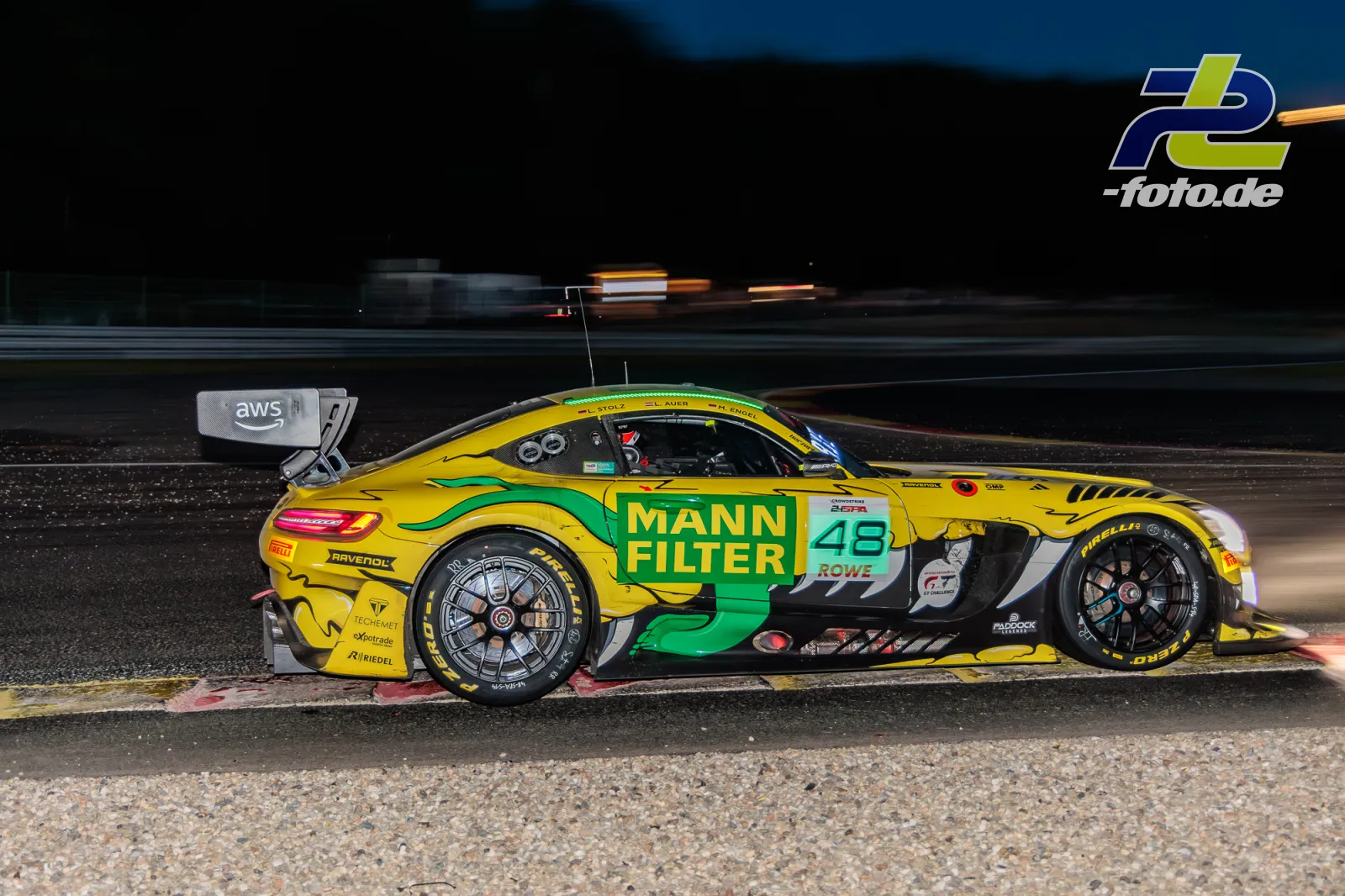Mercedes-AMG GT3 EVO #48 des MANN-FILTER Teams bei Nacht während der 24 Stunden von Spa, gelb-grüne Lackierung, Seitenansicht auf der Strecke.