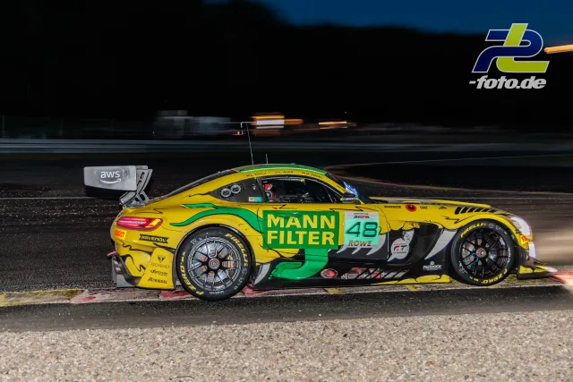 Mercedes-AMG GT3 EVO #48 des MANN-FILTER Teams bei Nacht während der 24 Stunden von Spa, gelb-grüne Lackierung, Seitenansicht auf der Strecke.
