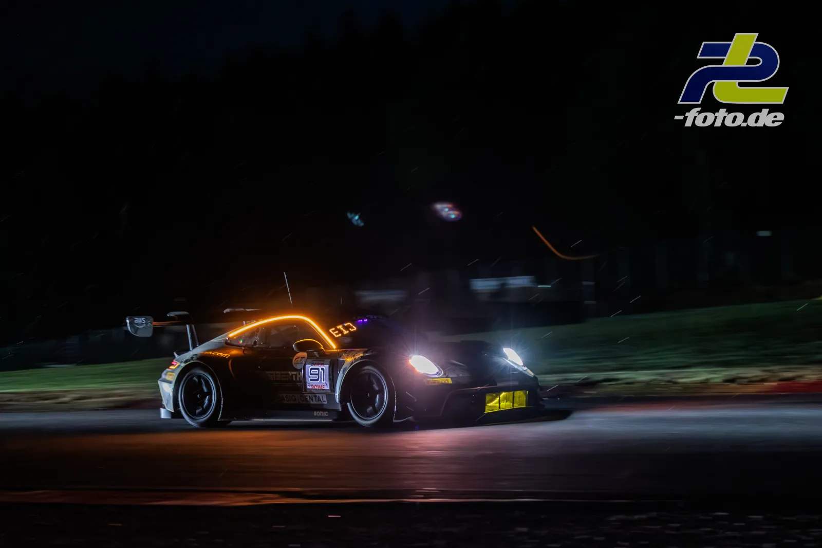 Porsche 911 GT3 R bei Nacht auf der Rennstrecke in Spa-Francorchamps, aufgenommen mit Mitzieher und Langzeitbelichtung.