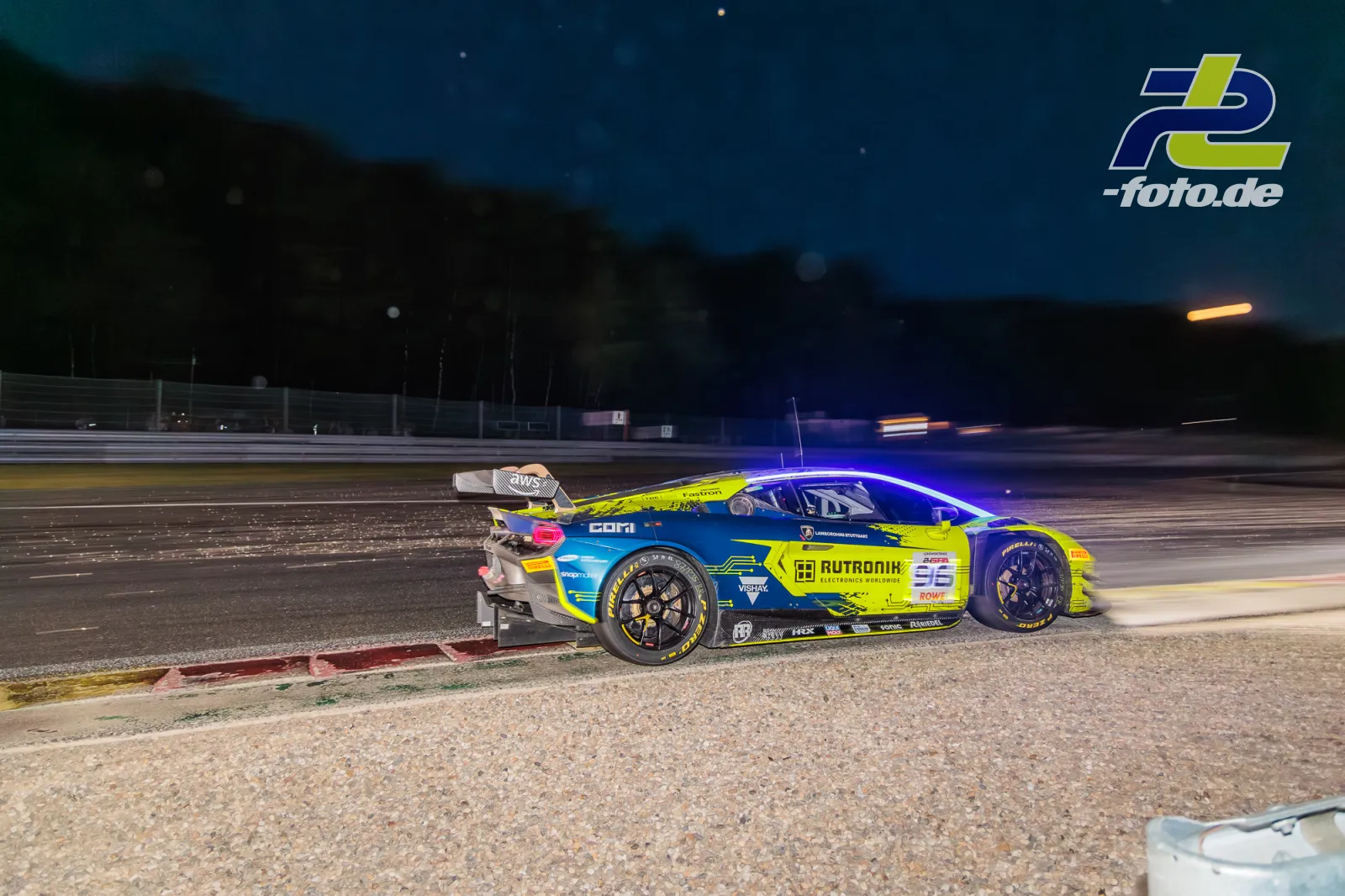 Lamborghini Temerario GT3 #96 von Rutronik Racing bei den 24 Stunden von Spa, nachts in der Auslaufzone mit Bergen im Hintergrund.