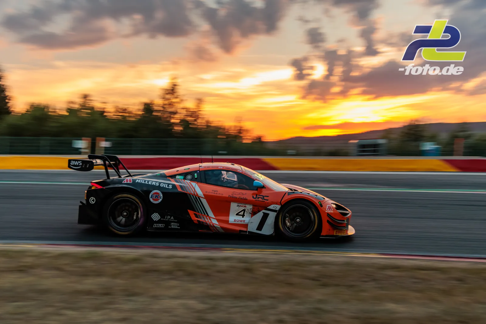 McLaren 720S GT3 EVO im Mitzieher bei Sonnenuntergang während der 24 Stunden von Spa-Francorchamps mit orangefarbenem Himmel.