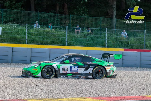 Porsche 911 GT3 R im Kiesbett beim 24-Stunden-Rennen von Spa-Francorchamps, Zuschauer beobachten vom Zaun aus.