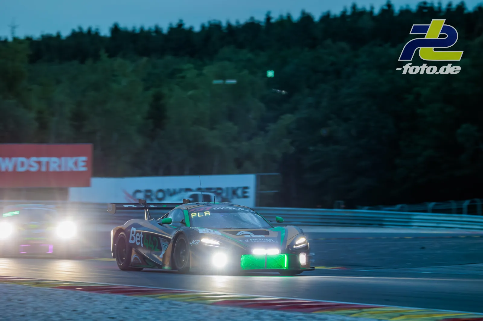 McLaren 720S GT3 EVO #111 von CSA Racing in der Dämmerung beim 24-Stunden-Rennen in Spa-Francorchamps mit eingeschalteten Scheinwerfern.