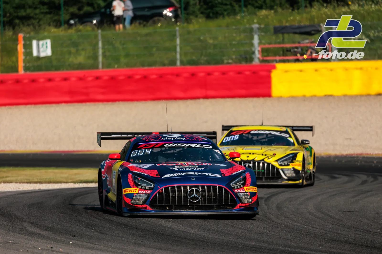 Mercedes-AMG GT3 EVO #3 führt gelbes Fahrzeug durch Kurve beim 24h-Rennen Spa-Francorchamps mit Kiesbett und Streckenbegrenzung.