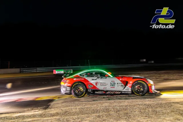Rennwagen bei Nacht auf der Strecke in Spa-Francorchamps während des 24-Stunden-Rennens, aufgenommen als Mitzieher mit Bewegungsunschärfe.
