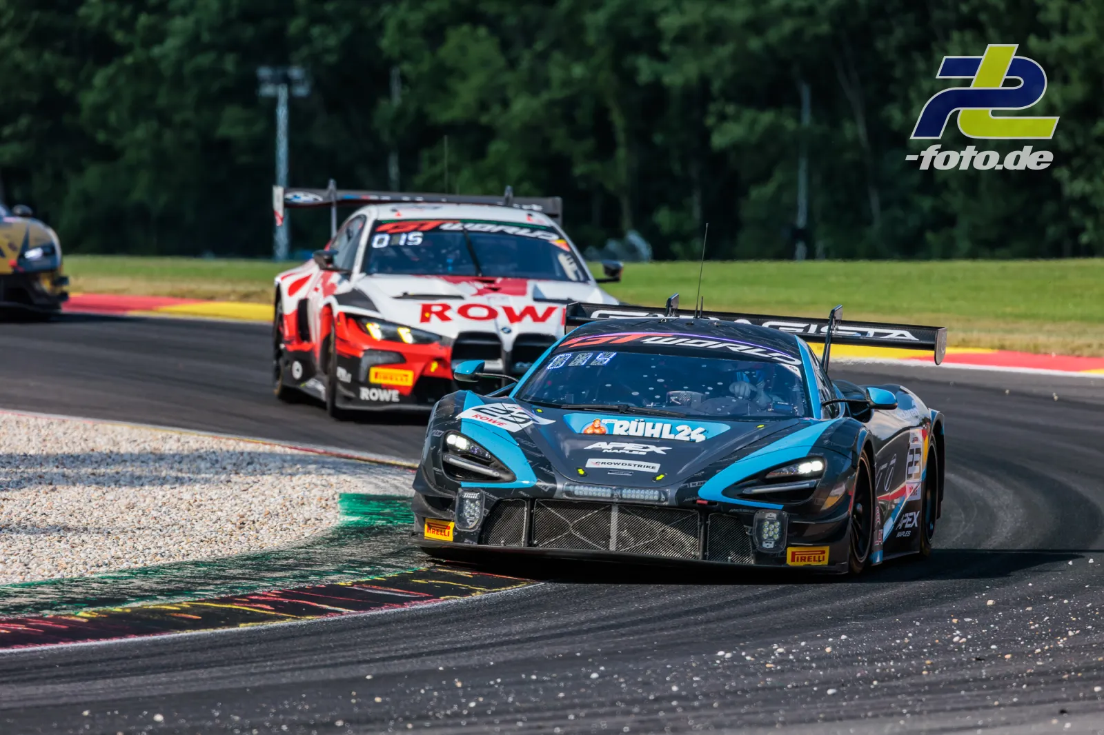McLaren 720S GT3 EVO des Team RJN in Kurve vor Verfolger beim 24-Stunden-Rennen in Spa-Francorchamps, Kiesbett und Randstein im Vordergrund.