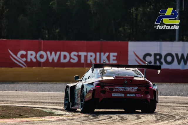 BMW M4 GT3 EVO, Startnummer 991, von hinten in Kurve auf dem Randstein beim 24-Stunden-Rennen von Spa-Francorchamps.