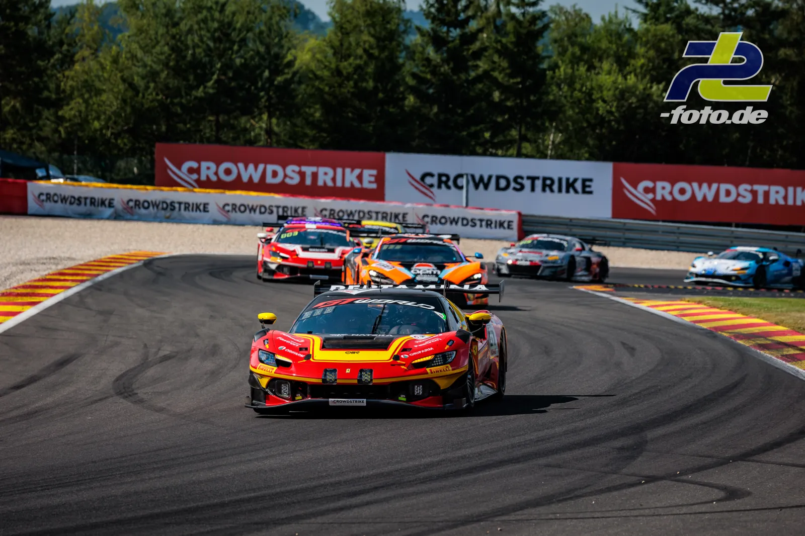 Ferrari 296 GT3 EVO Nr. 51 von AF Corse führt eine Fahrzeuggruppe durch eine Kurve beim 24-Stunden-Rennen von Spa-Francorchamps.
