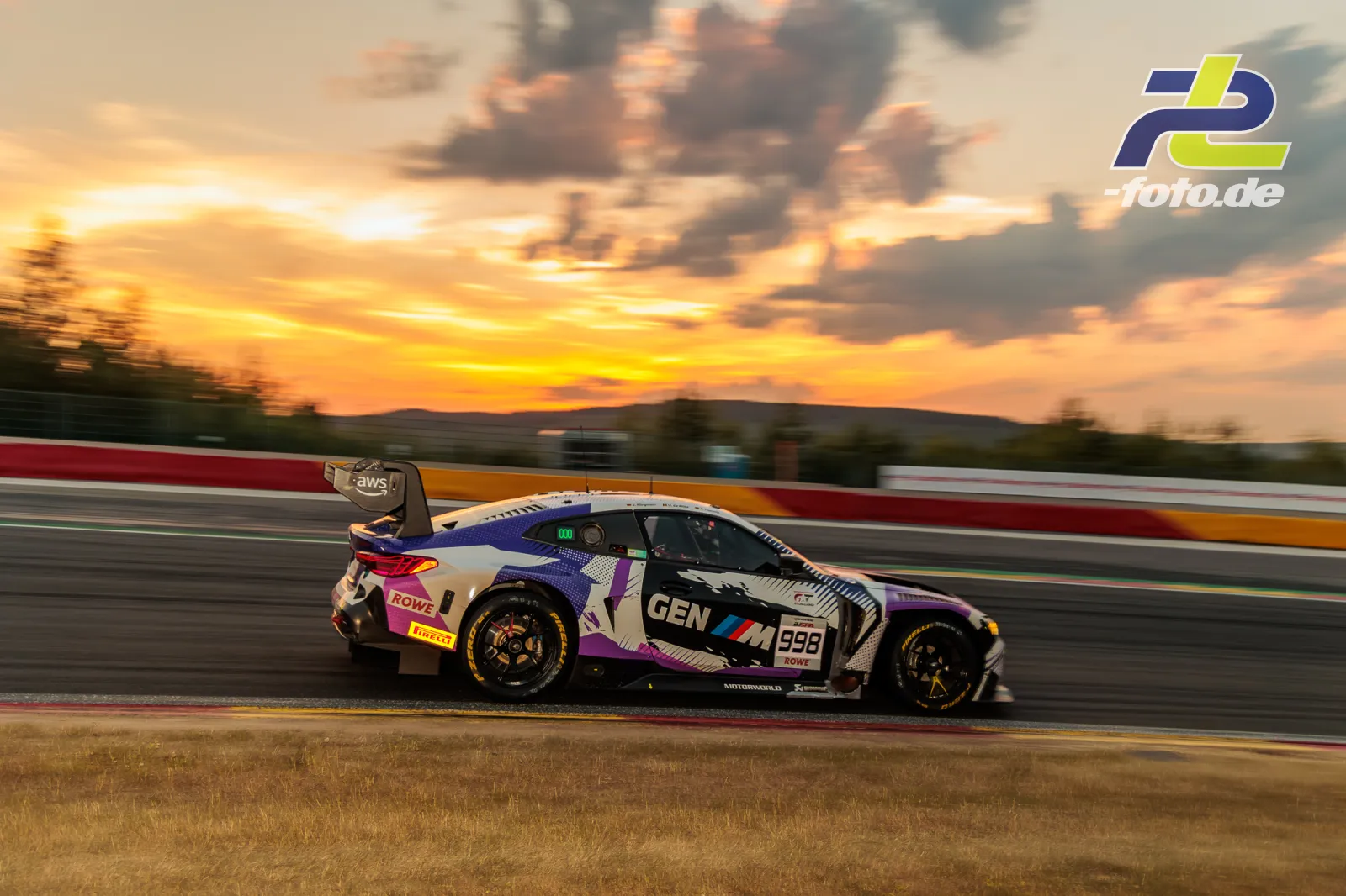 BMW M4 GT3 EVO des Rowe Racing beim 24-Stunden-Rennen von Spa bei Sonnenuntergang, Seitenansicht mit Mitzieher-Effekt