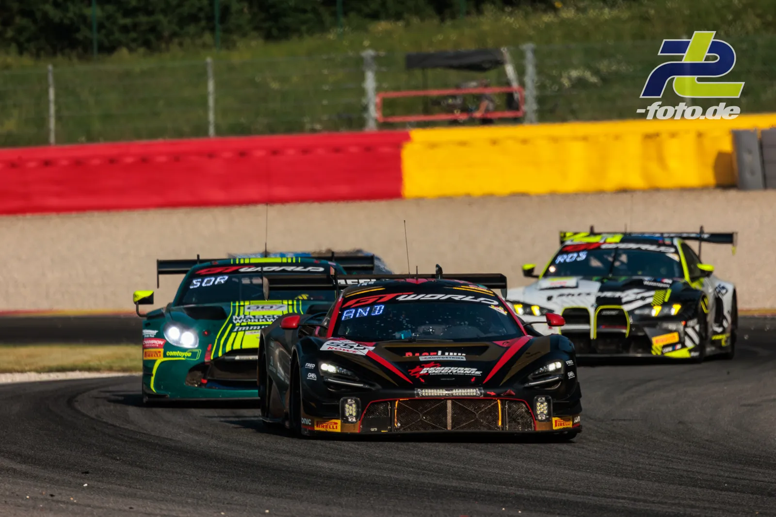 Drei GT3-Rennwagen im Zweikampf in der Kurve beim 24-Stunden-Rennen von Spa-Francorchamps, McLaren 720S GT3 EVO führt das Feld an.