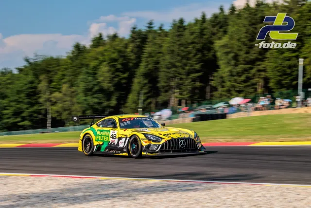 Gelber Mercedes-AMG GT3 EVO #48 in Fahrt auf der Rennstrecke beim 24-Stunden-Rennen von Spa-Francorchamps, Mitzieher mit Waldhintergrund.