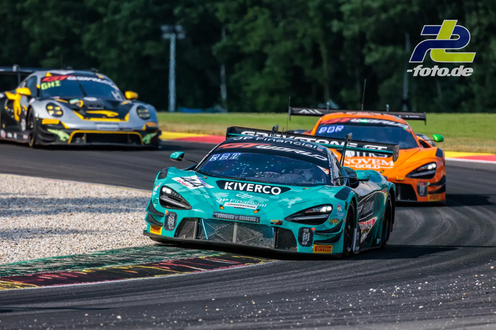 McLaren 720S GT3 EVO in türkis führt vor zwei Konkurrenten durch eine Kurve beim 24-Stunden-Rennen von Spa-Francorchamps.