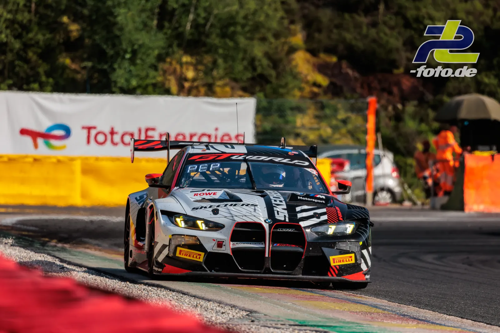 BMW M4 GT3 EVO des Team WRT auf der Rennstrecke beim 24-Stunden-Rennen in Spa-Francorchamps, Fahrzeug fährt über Randsteine.