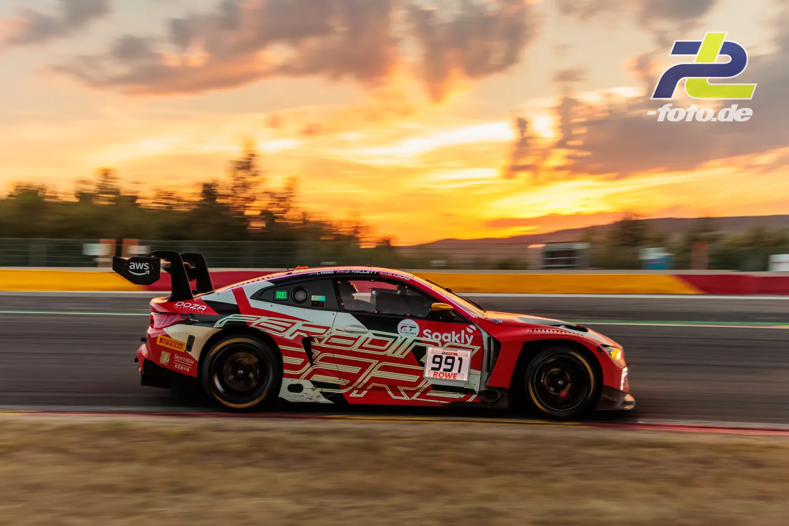 BMW M4 GT3 EVO mit Startnummer 991 von Paradine Competition in Seitenansicht bei Sonnenuntergang auf der Strecke in Spa-Francorchamps.