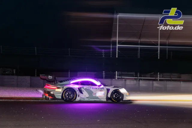 Porsche 911 GT3 R mit violettem LED-Lichtband bei Nacht auf der Rennstrecke in Spa-Francorchamps während des 24-Stunden-Rennens.