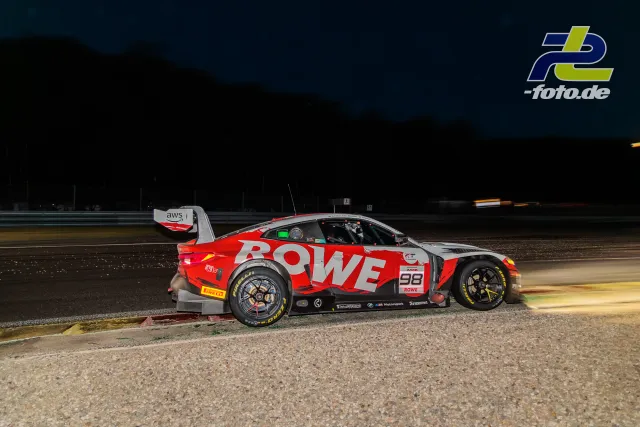 BMW M4 GT3 EVO von Rowe Racing steht nachts im Kiesbett neben der Strecke beim 24-Stunden-Rennen von Spa-Francorchamps.