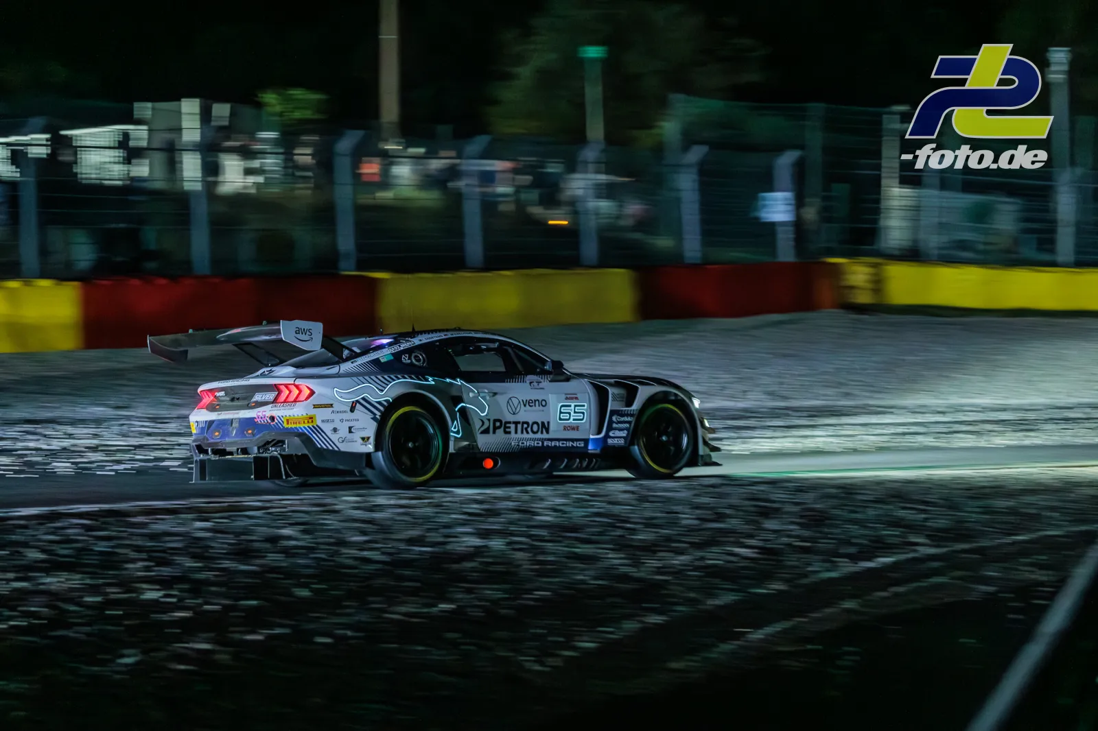 Ford Mustang GT3 EVO mit Startnummer 65 beim 24-Stunden-Rennen von Spa bei Nacht auf nasser Strecke.