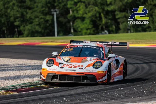 Porsche 911 GT3 R in orange-weißer Lackierung auf der Rennstrecke in Spa-Francorchamps beim 24-Stunden-Rennen, Kurvenausgang mit Kiesbett.
