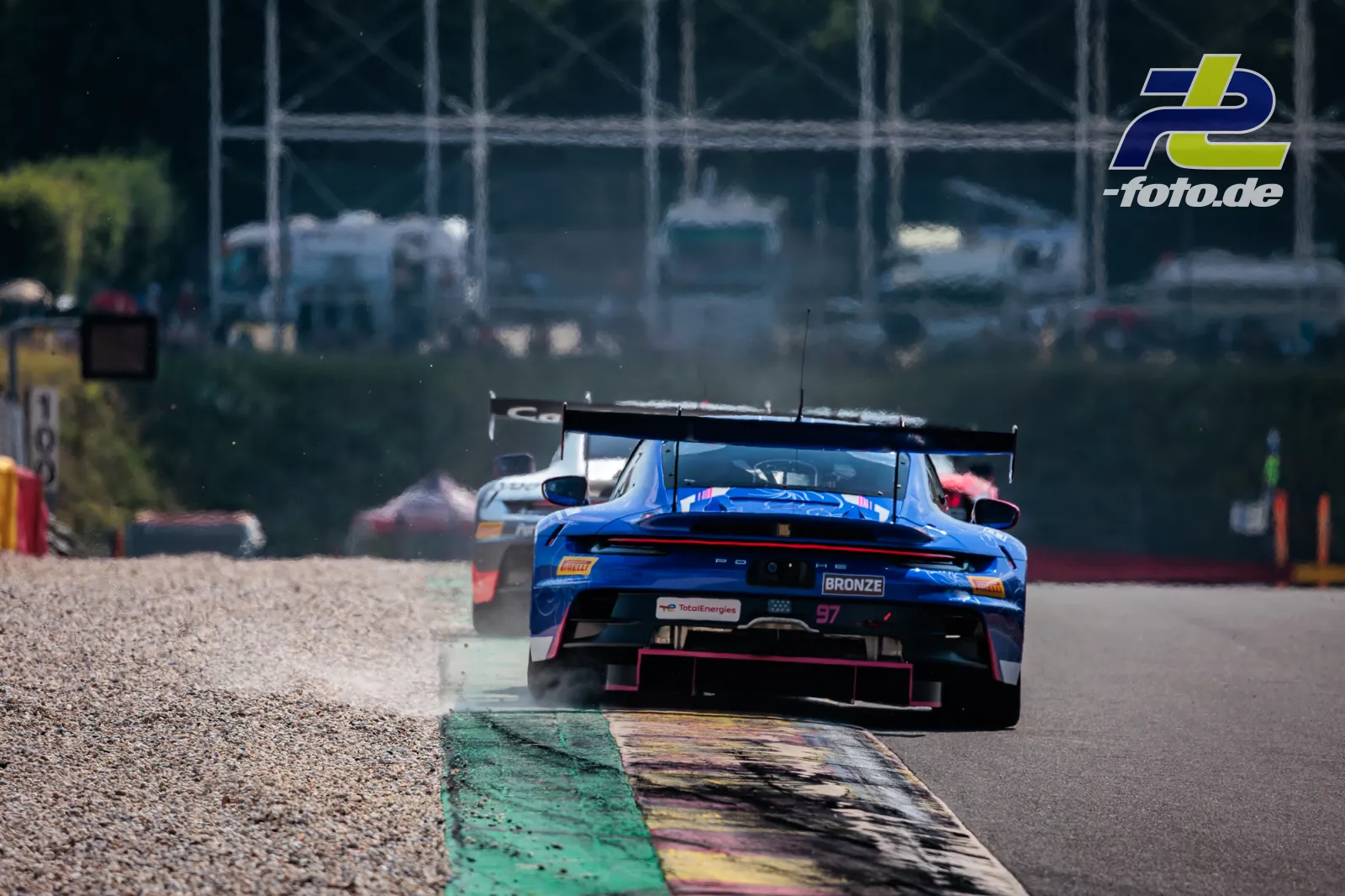 Porsche 911 GT3 R (992) EVO Nr. 97 von Rutronik Racing nutzt den Randstein in Spa-Francorchamps, verfolgt von weiteren Fahrzeugen.