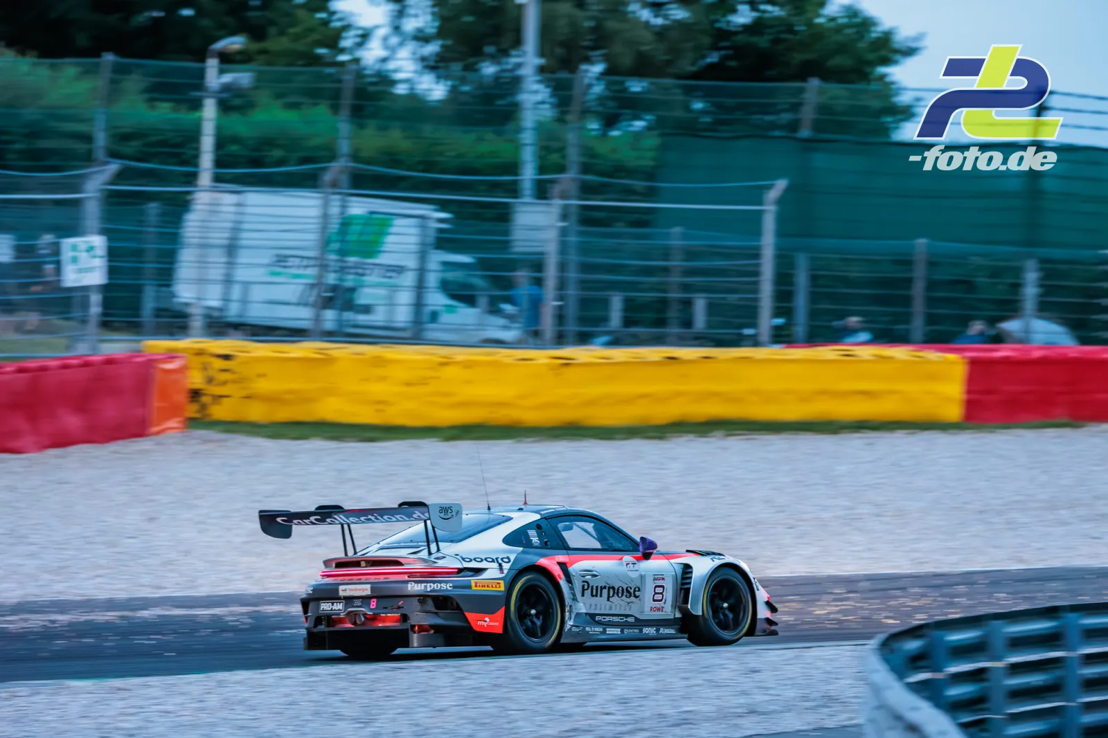 Porsche 911 GT3 R in hellblauer Lackierung mit rotem Heck beim 24-Stunden-Rennen von Spa-Francorchamps, Heckansicht in der Auslaufzone.