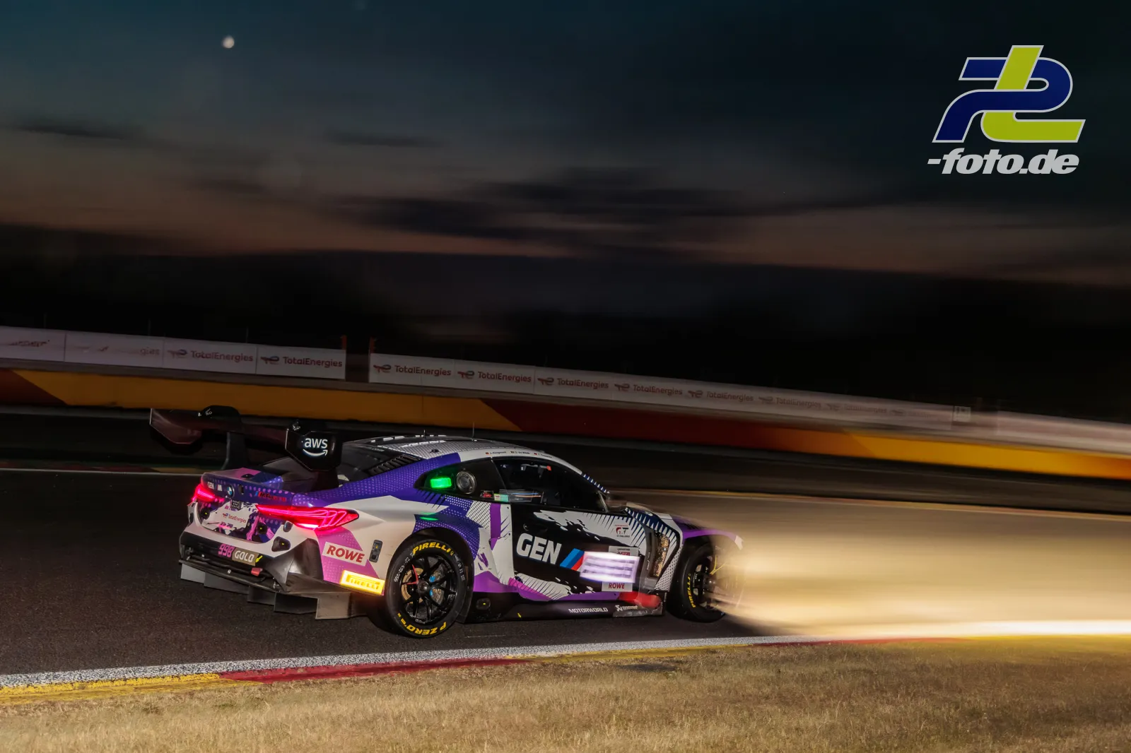 BMW M4 GT3 EVO von Rowe Racing bei Nacht auf dem Circuit de Spa-Francorchamps während des 24-Stunden-Rennens, Mitzieher mit Flammen am Auspuff.
