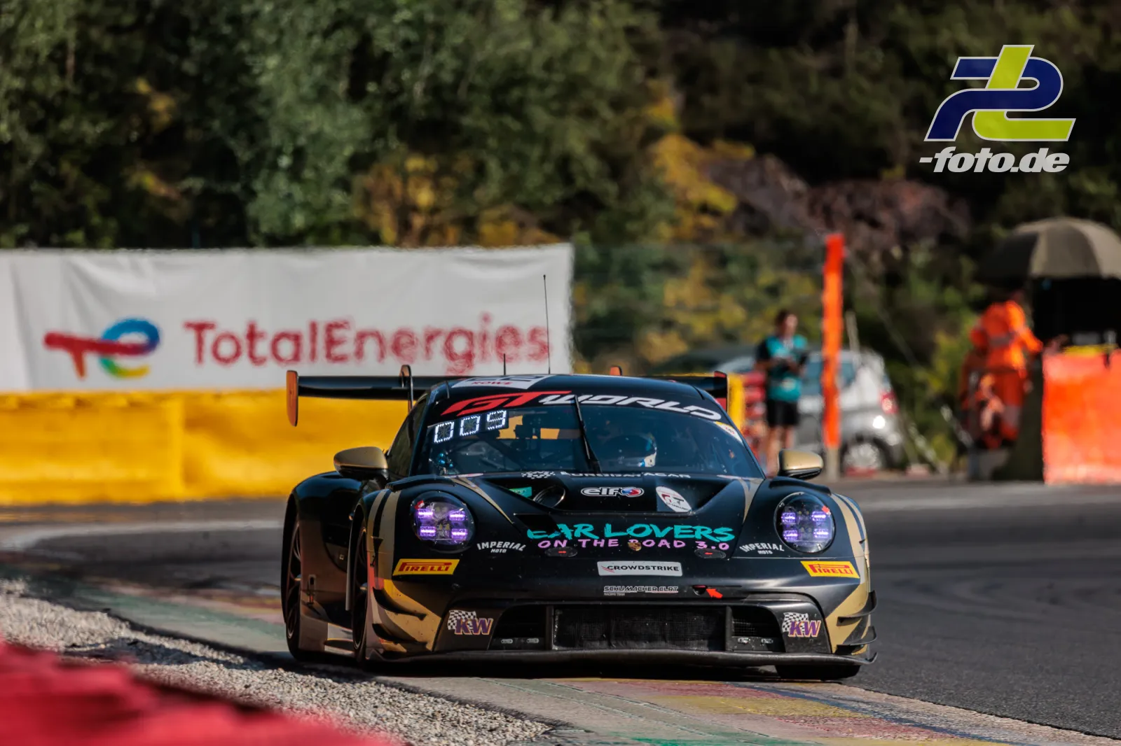 Porsche 911 GT3 R Nr. 22 von Schumacher CLRT beim 24-Stunden-Rennen in Spa-Francorchamps, fahrend über Randstein in einer Kurve.