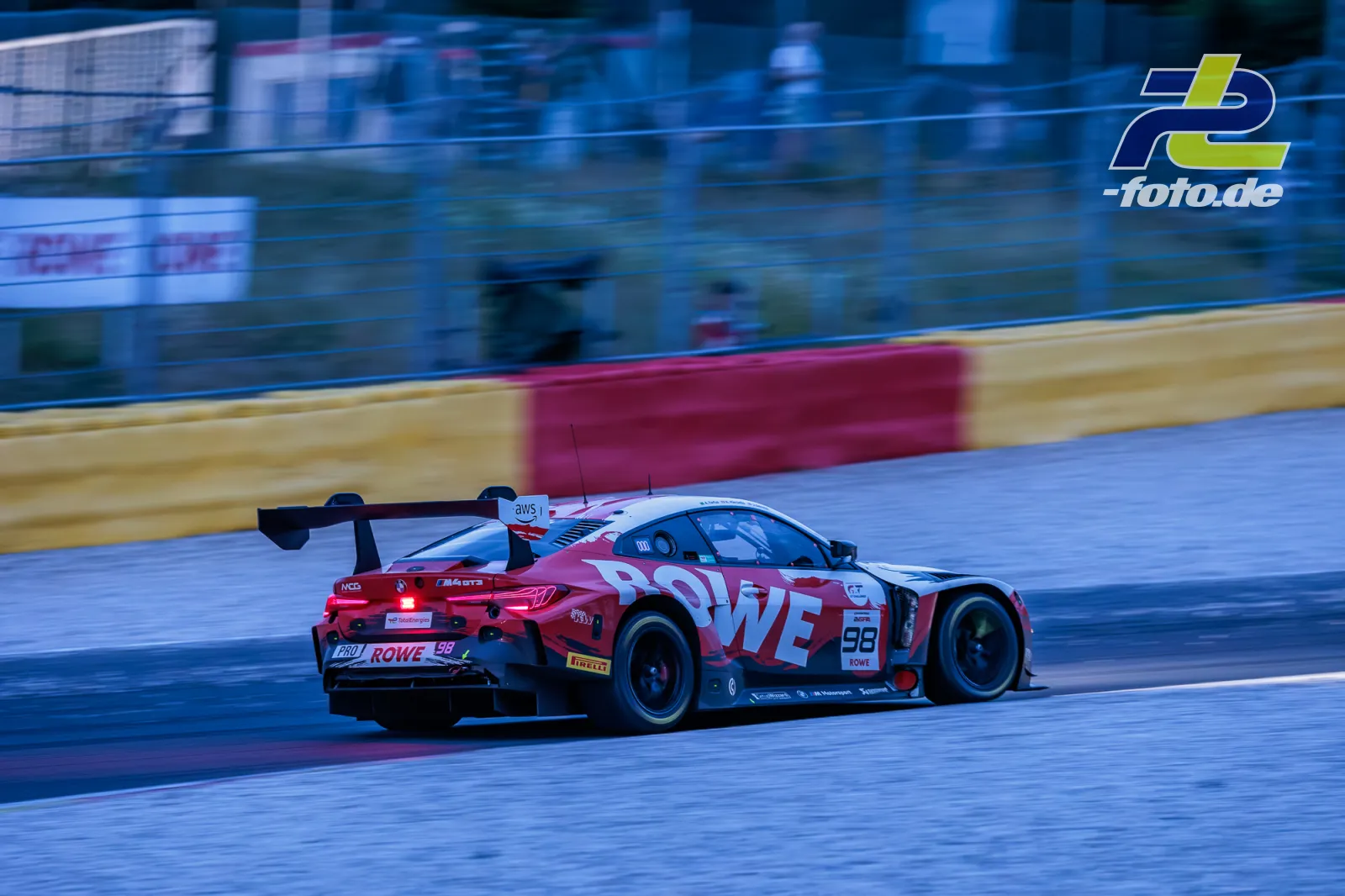 BMW M4 GT3 EVO von Rowe Racing bei den 24 Stunden von Spa-Francorchamps während der Dämmerung auf der Strecke.