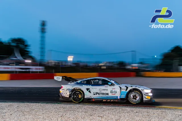BMW M4 GT3 des Teams Petron in der Dämmerung auf der Strecke in Spa-Francorchamps beim 24-Stunden-Rennen, Mitzieher-Aufnahme.