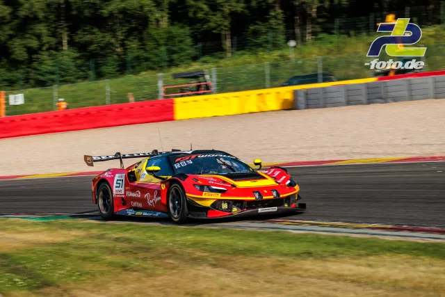 Ein Ferrari 296 GT3 EVO beim 24-Stunden-Rennen von Spa-Francorchamps auf der Strecke neben dem Kiesbett mit rot-gelben Streckenbegrenzungen.