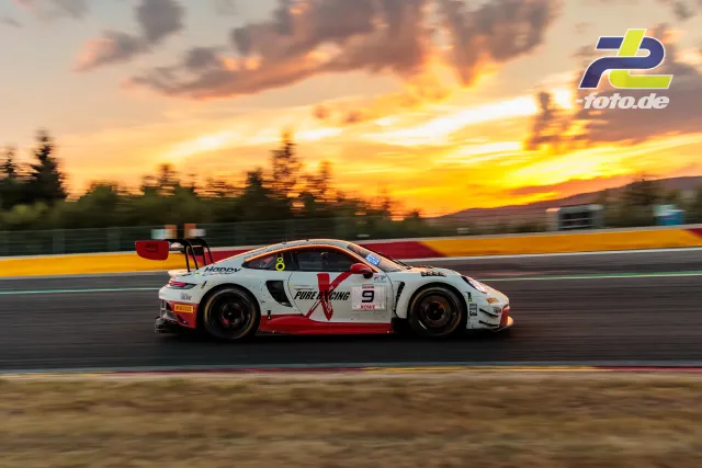 Porsche 911 GT3 R mit rot-weißer Lackierung auf der Strecke bei Sonnenuntergang während der 24 Stunden von Spa-Francorchamps.