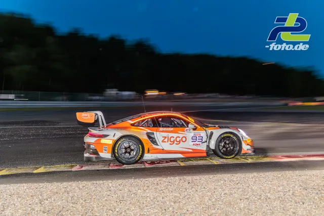 Porsche 911 GT3 R beim 24-Stunden-Rennen von Spa-Francorchamps in der Dämmerung, Seitenansicht an der Randsteinbegrenzung.