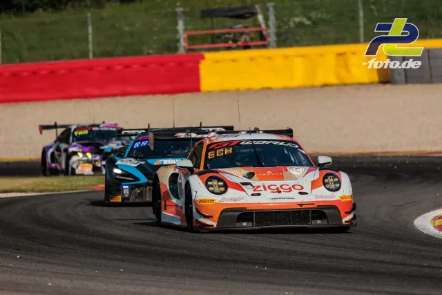 Porsche 911 GT3 R in orange-weiß führt eine Gruppe von GT-Fahrzeugen durch eine Kurve beim 24-Stunden-Rennen von Spa-Francorchamps.