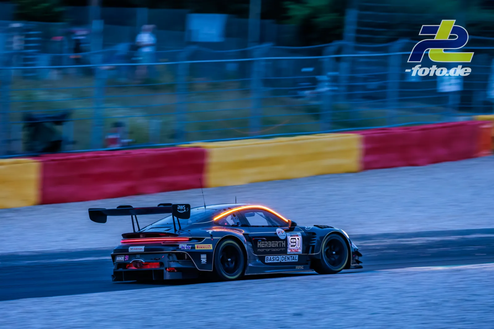 Porsche 911 GT3 R mit Startnummer 91 bei Dämmerung auf nasser Strecke beim 24-Stunden-Rennen von Spa-Francorchamps