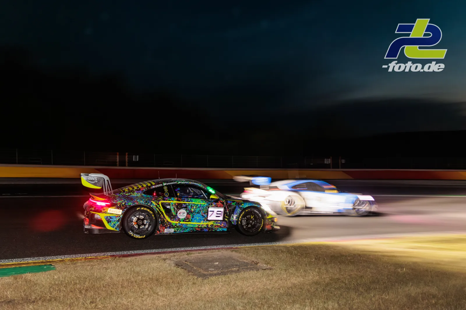 Porsche 911 GT3 R mit bunter Lackierung bei Nacht auf dem Circuit de Spa-Francorchamps während des 24-Stunden-Rennens, Mitzieher.