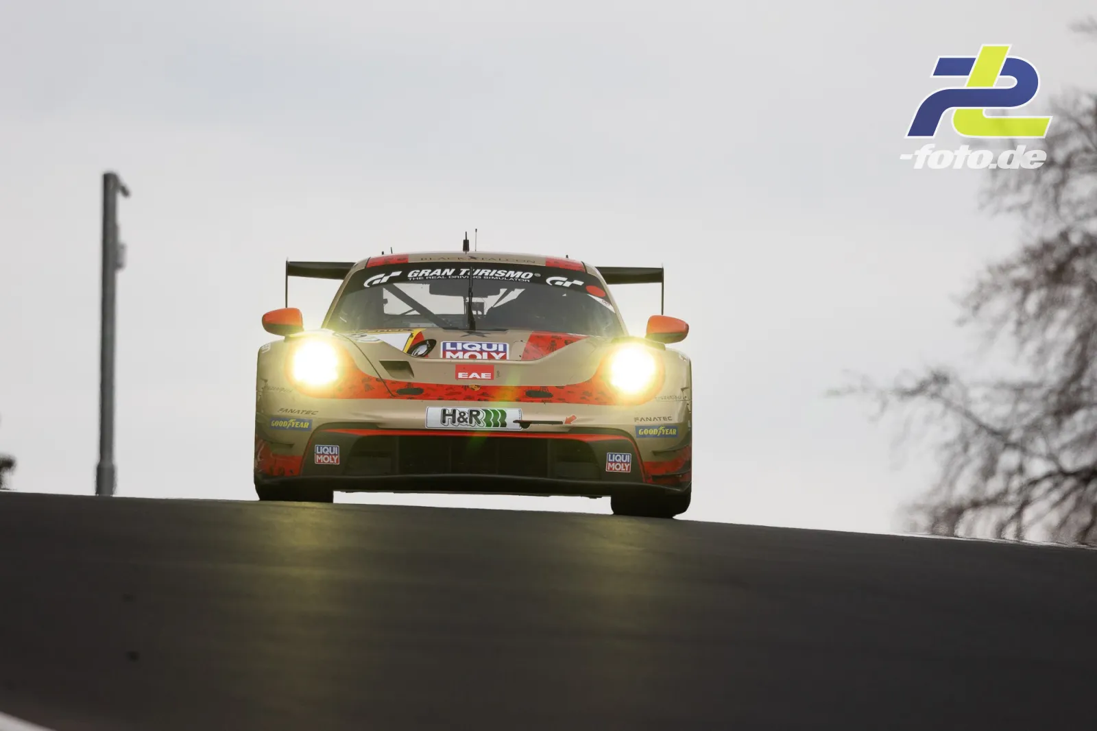 GT3-Rennwagen mit Lichtern in Kuppe während des 58. ADAC Barbarossapreis am Nürburgring bei bedecktem Wetter