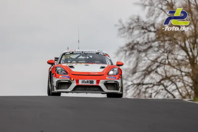 Porsche Cayman GT4 in orange-weißer Lackierung auf der Kuppe, Nürburgring NLS