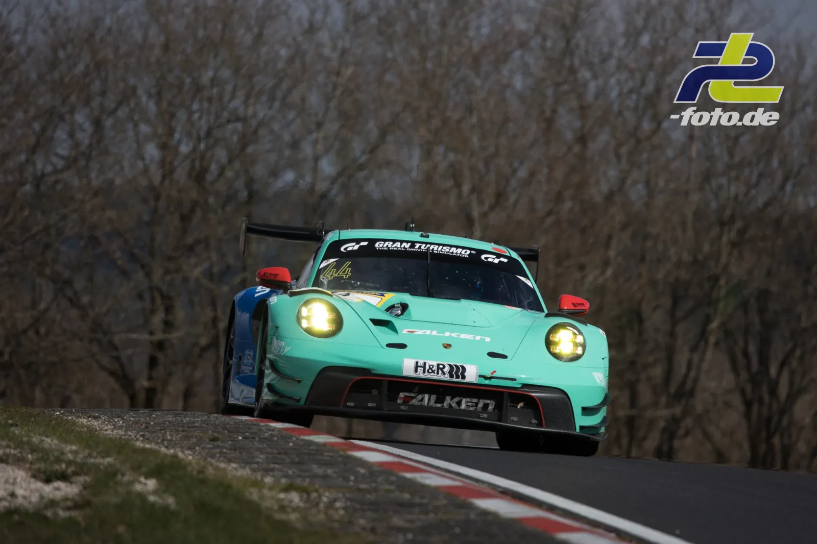 Türkisfarbener Porsche 911 GT3 R mit Falken-Lackierung in Kuppe auf der Nordschleife, NLS Barbarossapreis.