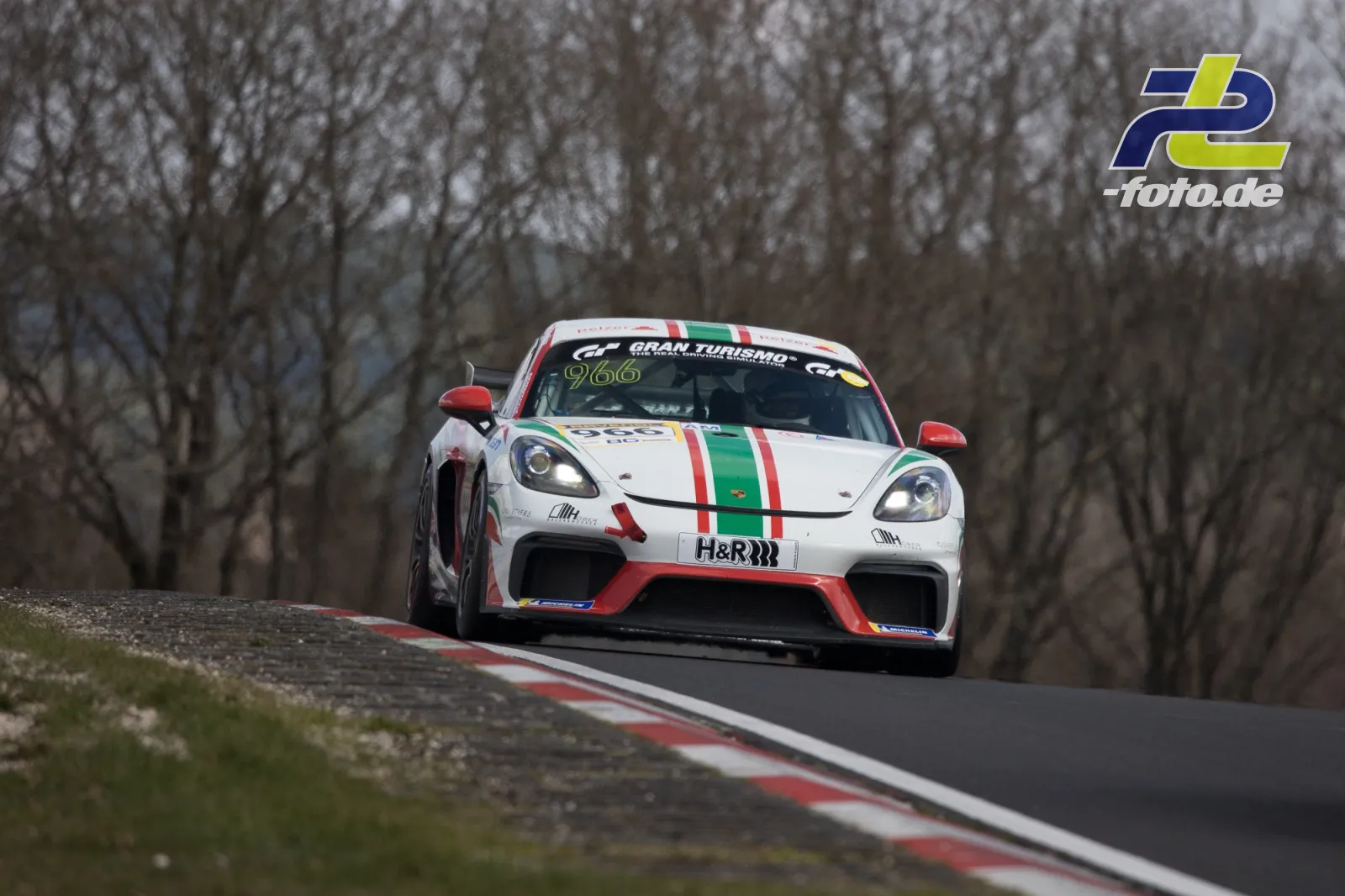 Porsche 718 Cayman GT4 #966 mit Italien-Lackierung in einer Kurve auf der Nürburgring Nordschleife beim NLS-Rennen.