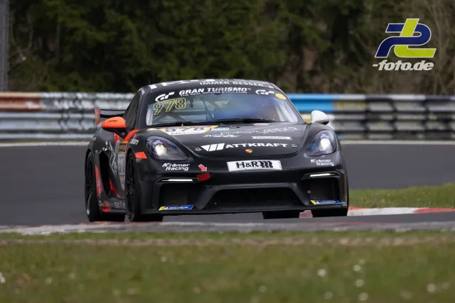 Schwarzer Porsche 718 Cayman GT4 #978 von Kremer Racing in Kurve auf dem Nürburgring beim NLS-Rennen.