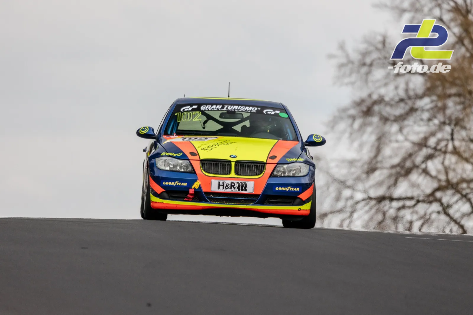 BMW Rennwagen mit Startnummer 102 in bunter Lackierung frontal auf der Bergkuppe der Nordschleife