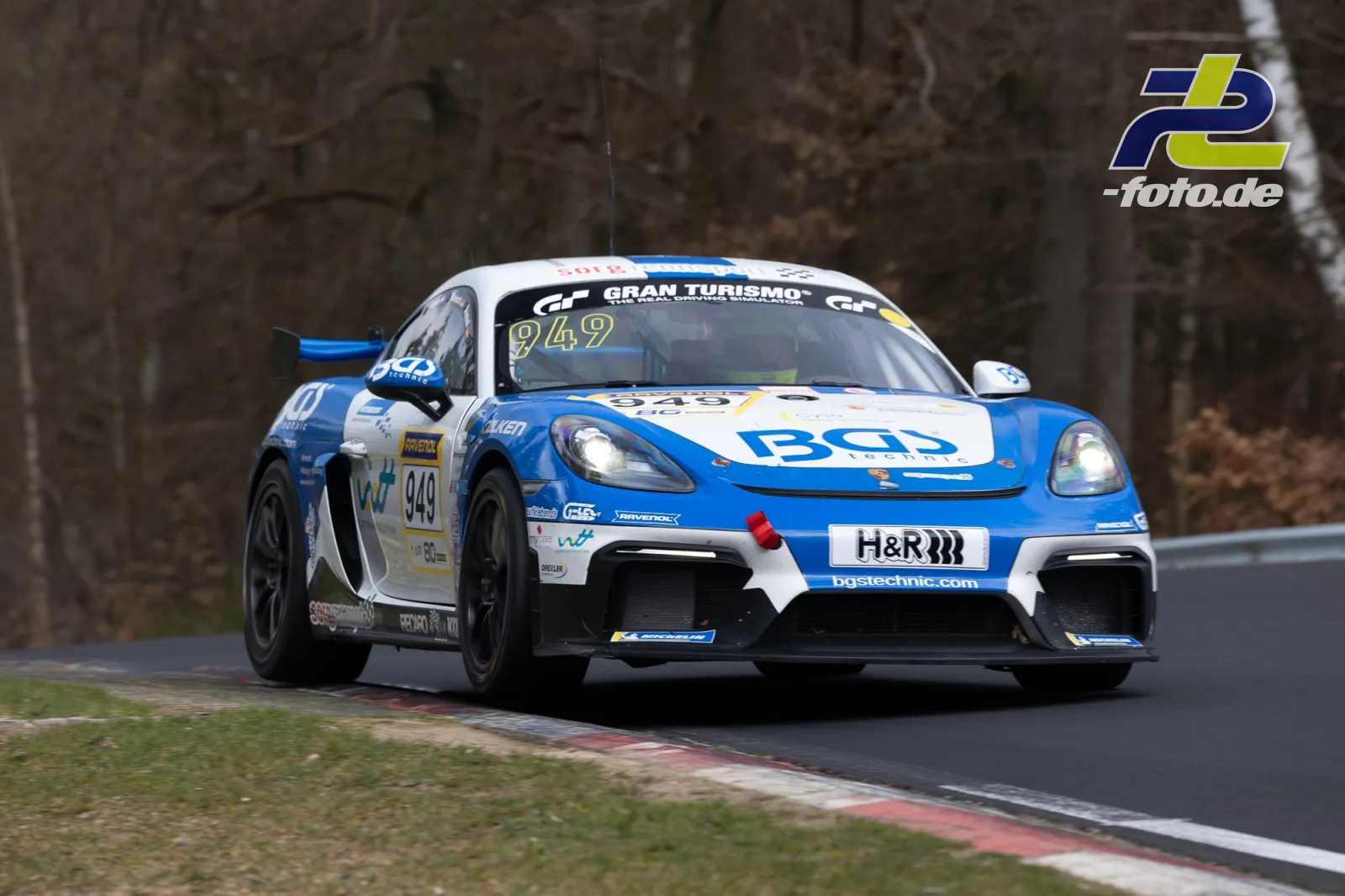 Porsche 718 Cayman GT4 Clubsport in blau-weißer BCO-Lackierung bei der NLS auf der Nordschleife, fahrend durch Kurve.
