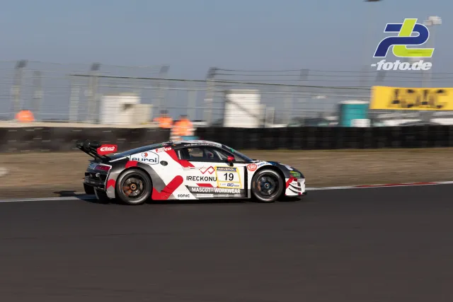 Audi R8 LMS Startnummer 19 in weiß-roter Lackierung während des Zeittrainings auf dem Nürburgring, Seitenansicht in Fahrt.