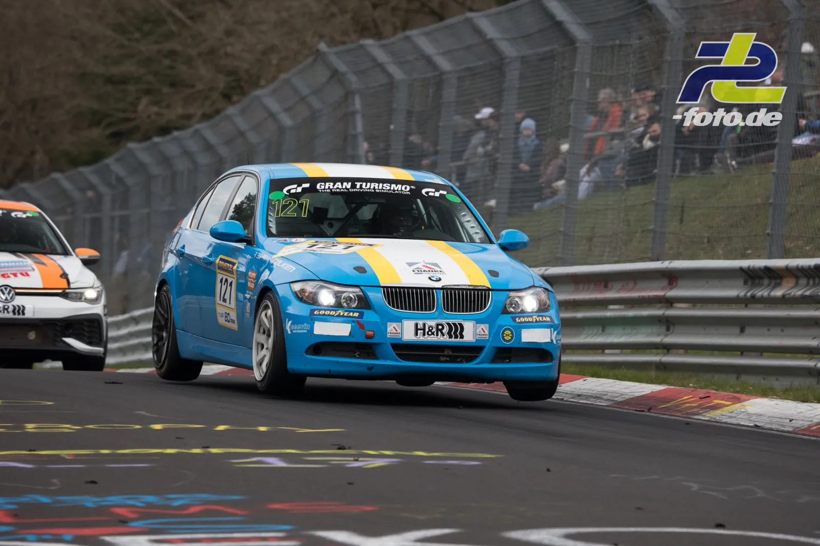 Blauer BMW 3er Limousine mit Startnummer 121 in Kurve auf der Nordschleife, gefolgt von einem VW.