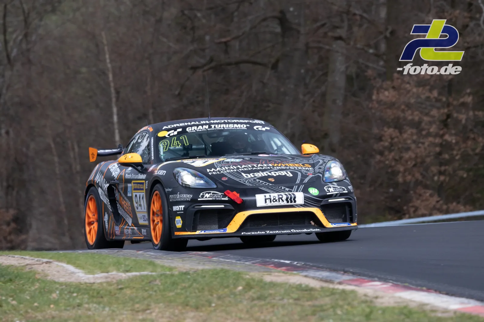 Porsche Cayman GT4 Clubsport mit schwarz-oranger Lackierung auf der Nordschleife des Nürburgrings